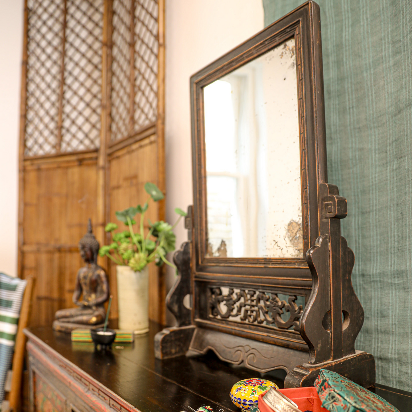 Vintage carved wooden mirror on tibetan cabinet display