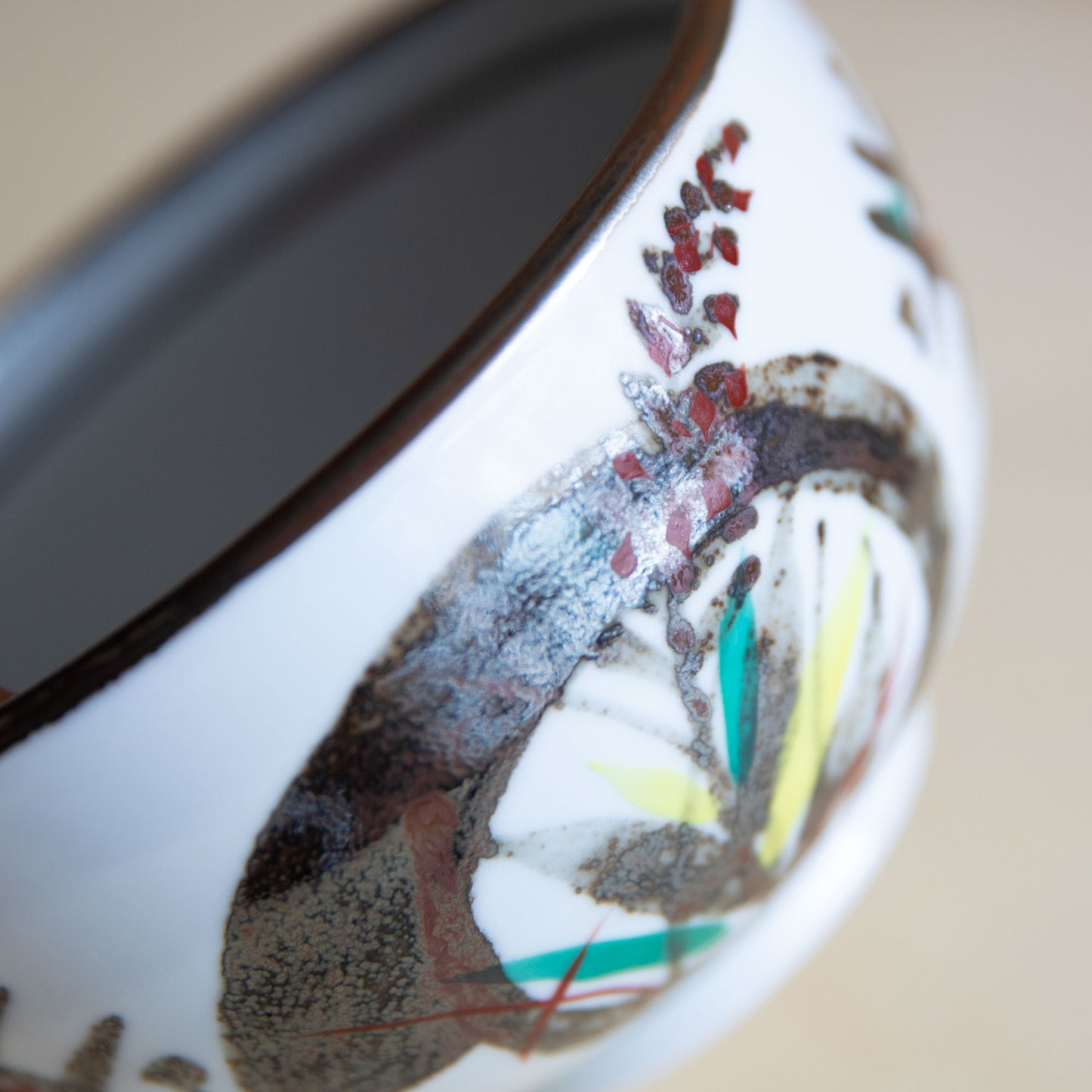 Ceramic cup with artistic design on a beige background