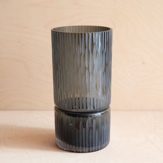 Smoky gray textured glass vase on a beige background