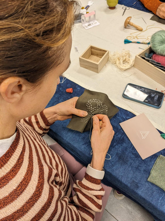 Visible mending workshop at Rouge in London using a darning mushroom and a sashiko stencil