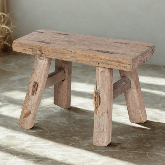 Wooden stool with rustic design on a marble floor
