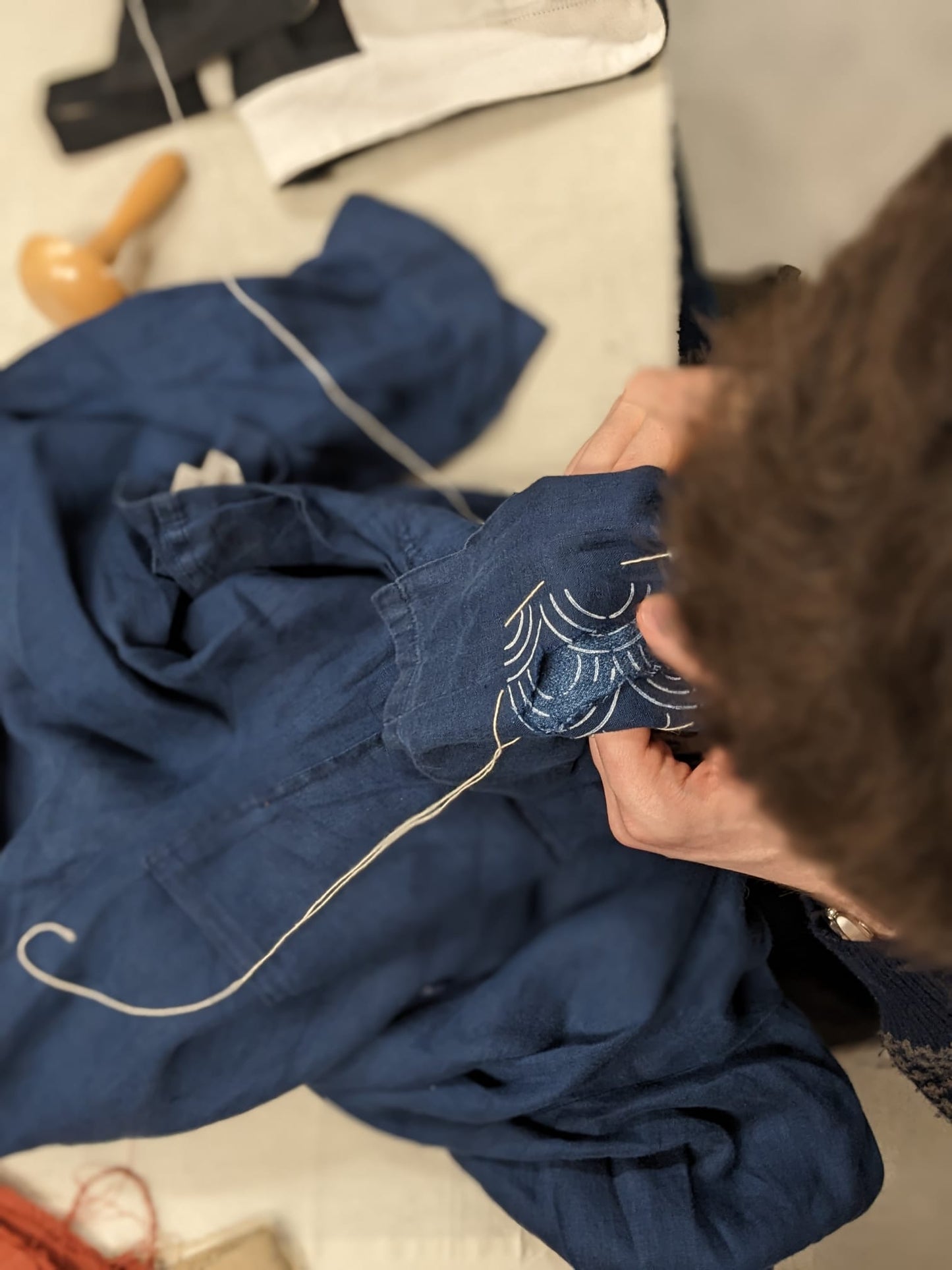 Visible mending workshop at Rouge in London using a darning mushroom and a sashiko stencil