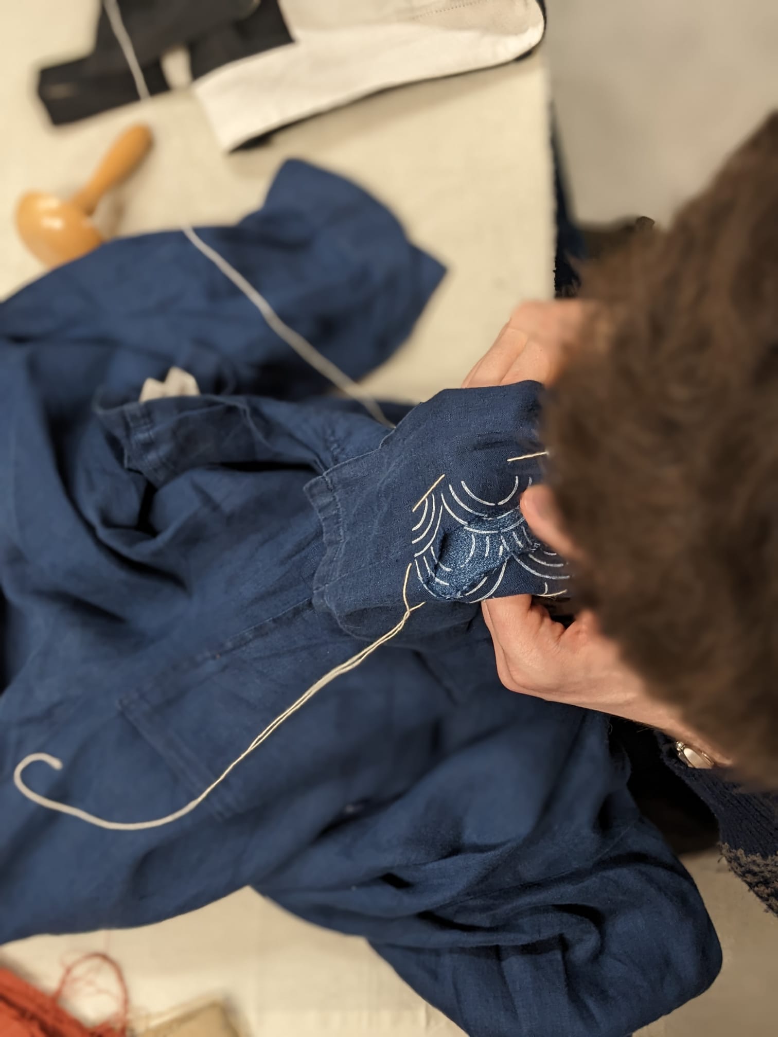 Visible mending workshop at Rouge in London using a darning mushroom and a sashiko stencil