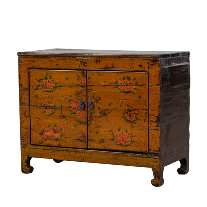 Vintage orange wooden cabinet with floral designs on a white background