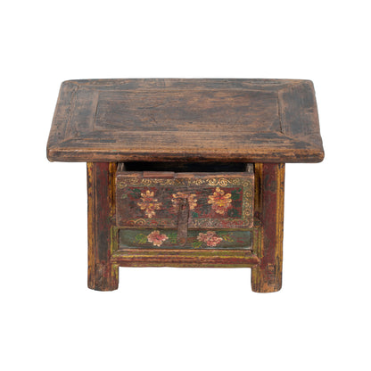 Vintage wooden stool with decorative carvings on a white background