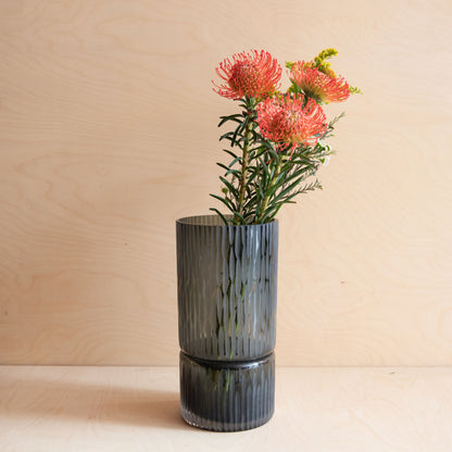 Gray textured vase with pink flowers against a beige background