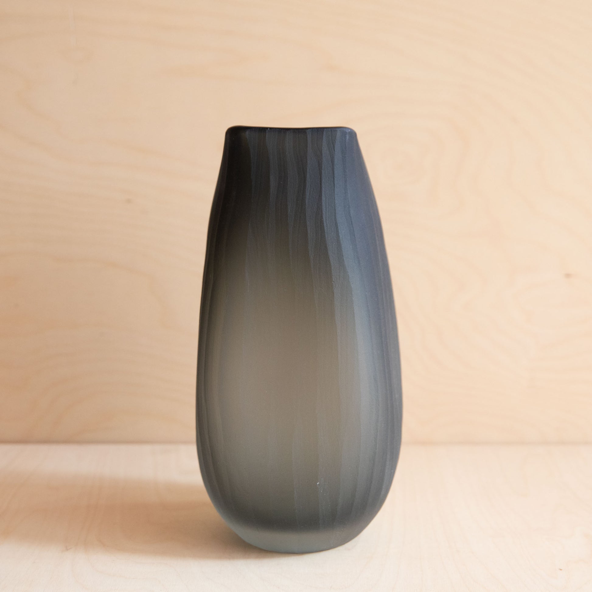Gradient grey vase on a beige background