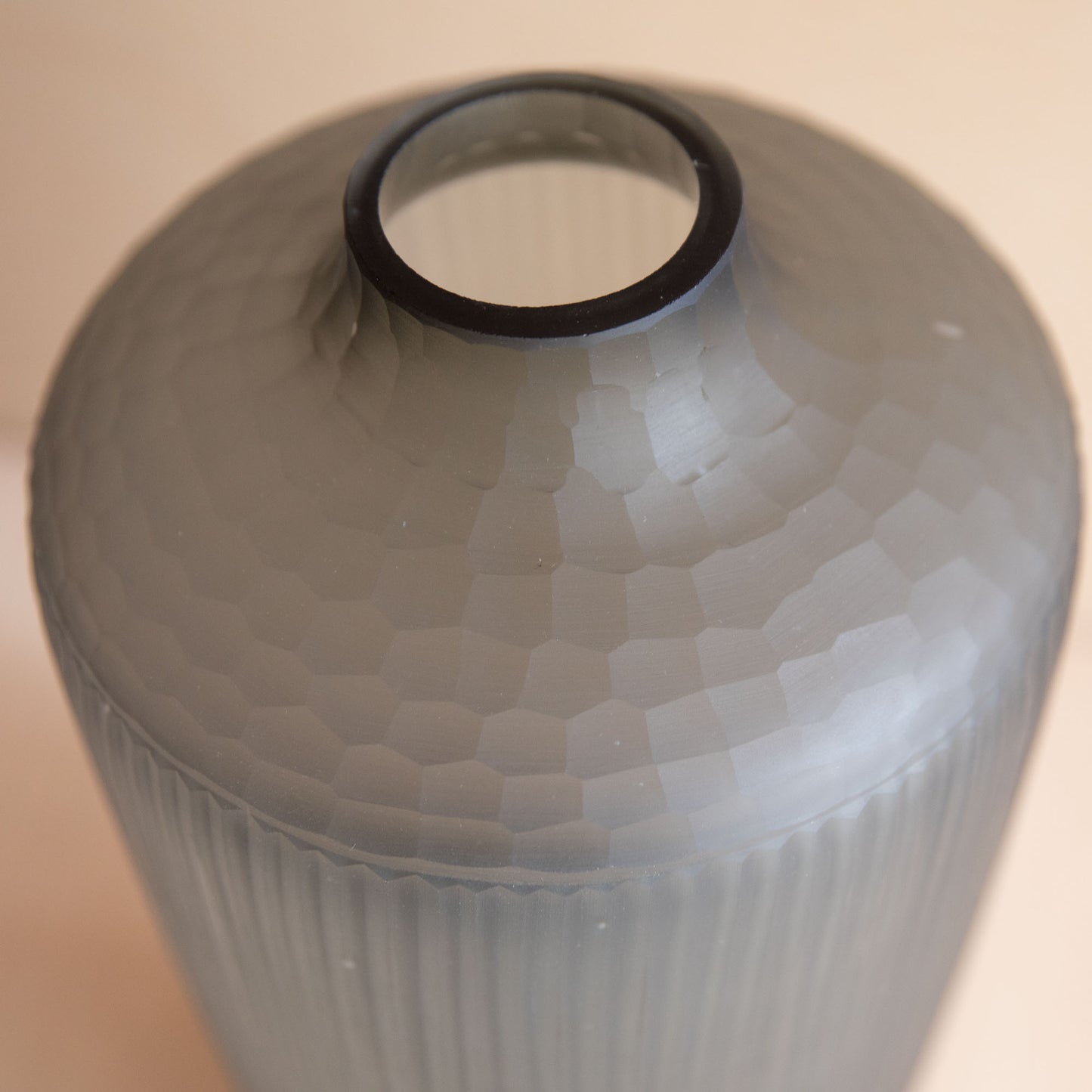 Close-up of a textured ceramic vase with a beige background