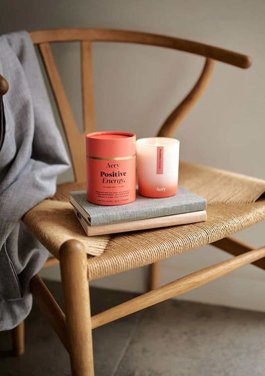 Positive Energy Scented Candle-Pink Grapefruit Vertiver and Mint on a chair